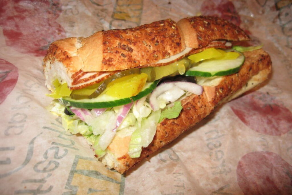Fully assembled cold cut Subway sandwich, ready for reheating.