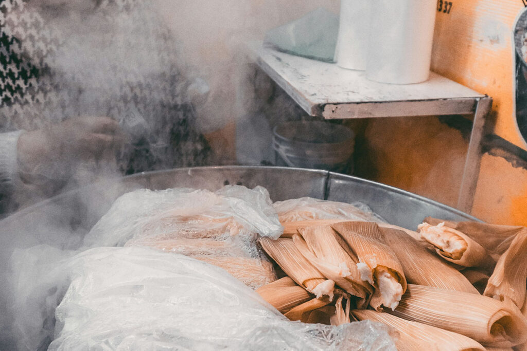 Woman in Mexico steaming tamales in a large pot