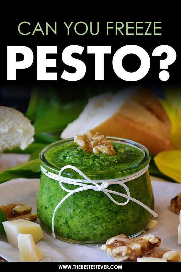 Pesto in a jar surrounded by bread and cheese