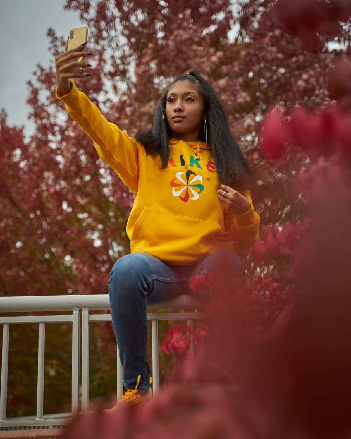 Woman in a Yellow Sweatshirt Sitting on a Fence Looking Good 'AF'