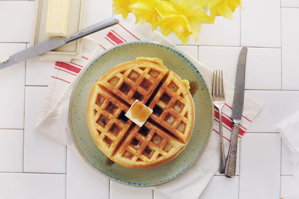 Waffles with butter and syrup sitting on a plate