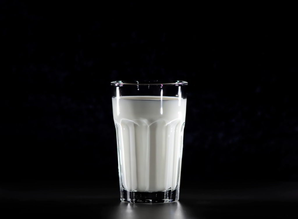 A glass of milk, with a black background