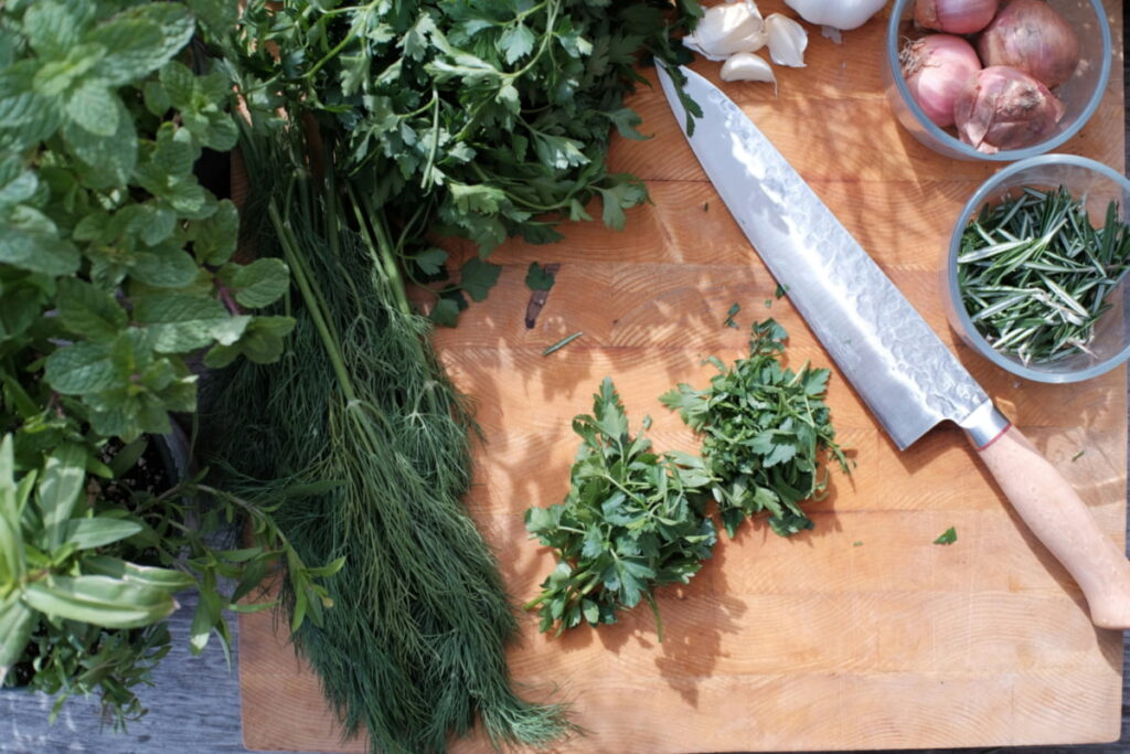 Overhead view of fresh herbs commonly used to season eggs, including dill, parsley, chives, and basil