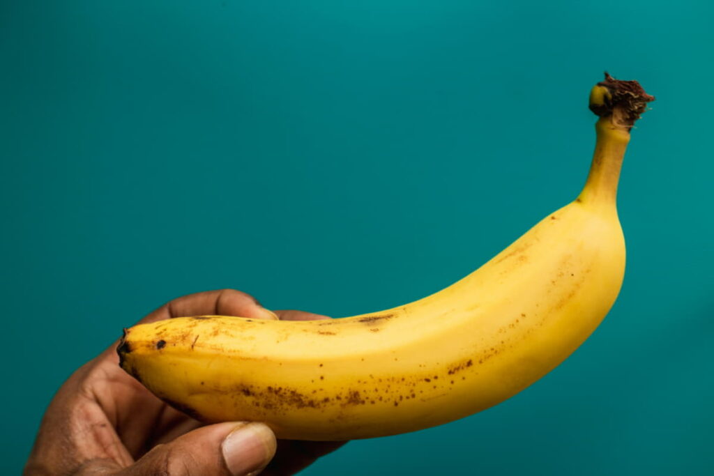 closeup shot of a man holding a banana