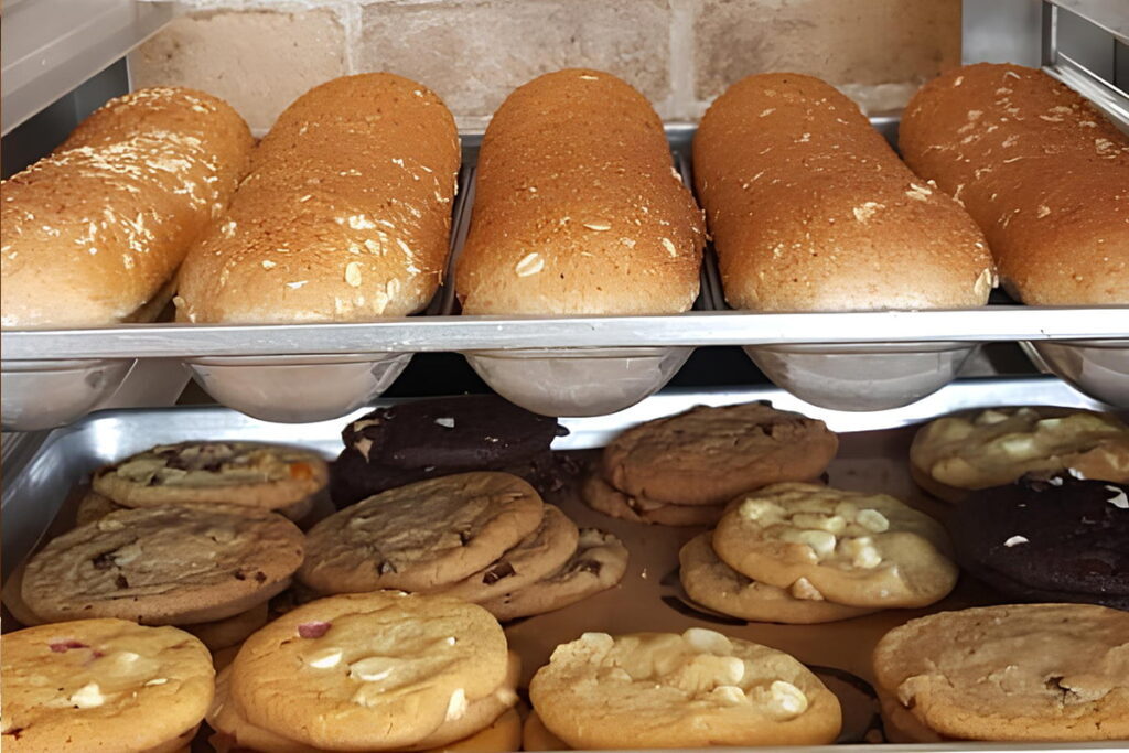 Tray of freshly baked Subway bread and cookies cooling together, blending sweet and savory aromas.