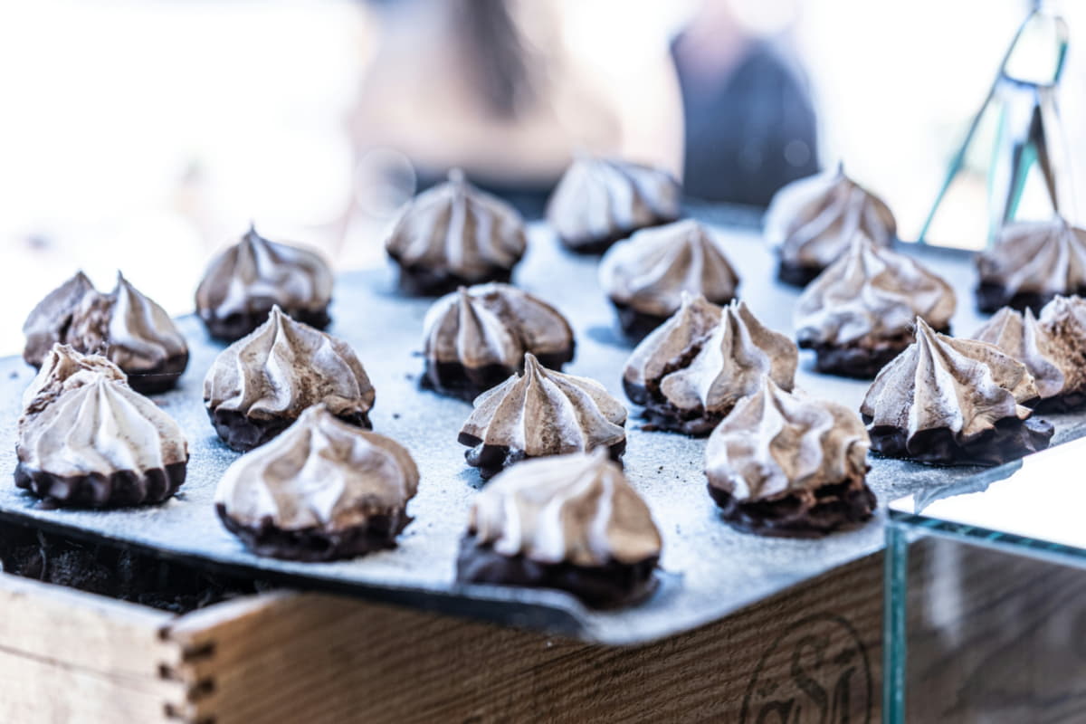 Meringue cookies arranged on a baking sheet.