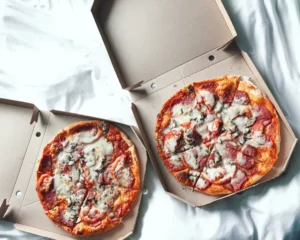 Overhead view of two 12-inch medium pizzas in cardboard boxes, showcasing different toppings and variety for a group order.