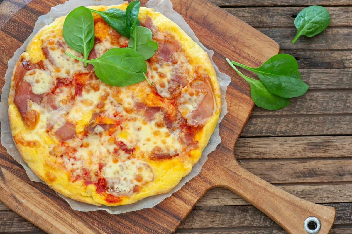 a whole almond flour pizza showing a golden crust topped with cheese and tomato sauce