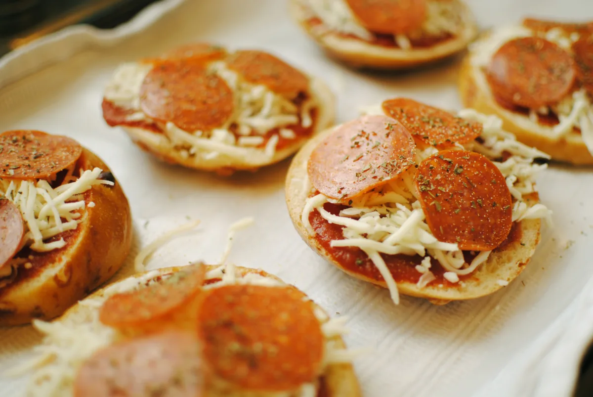 Toasted bagel halves topped with pizza sauce, mozzarella and pepperoni