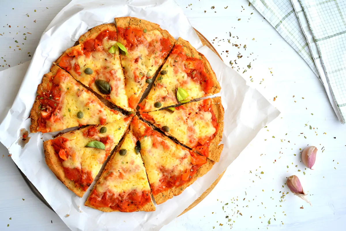 Cauliflower crust pizza with melted mozzarella, tomato sauce and fresh basil