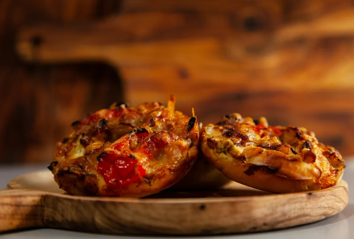 Two English muffin halves topped with tomato sauce, melted cheese and pepperoni