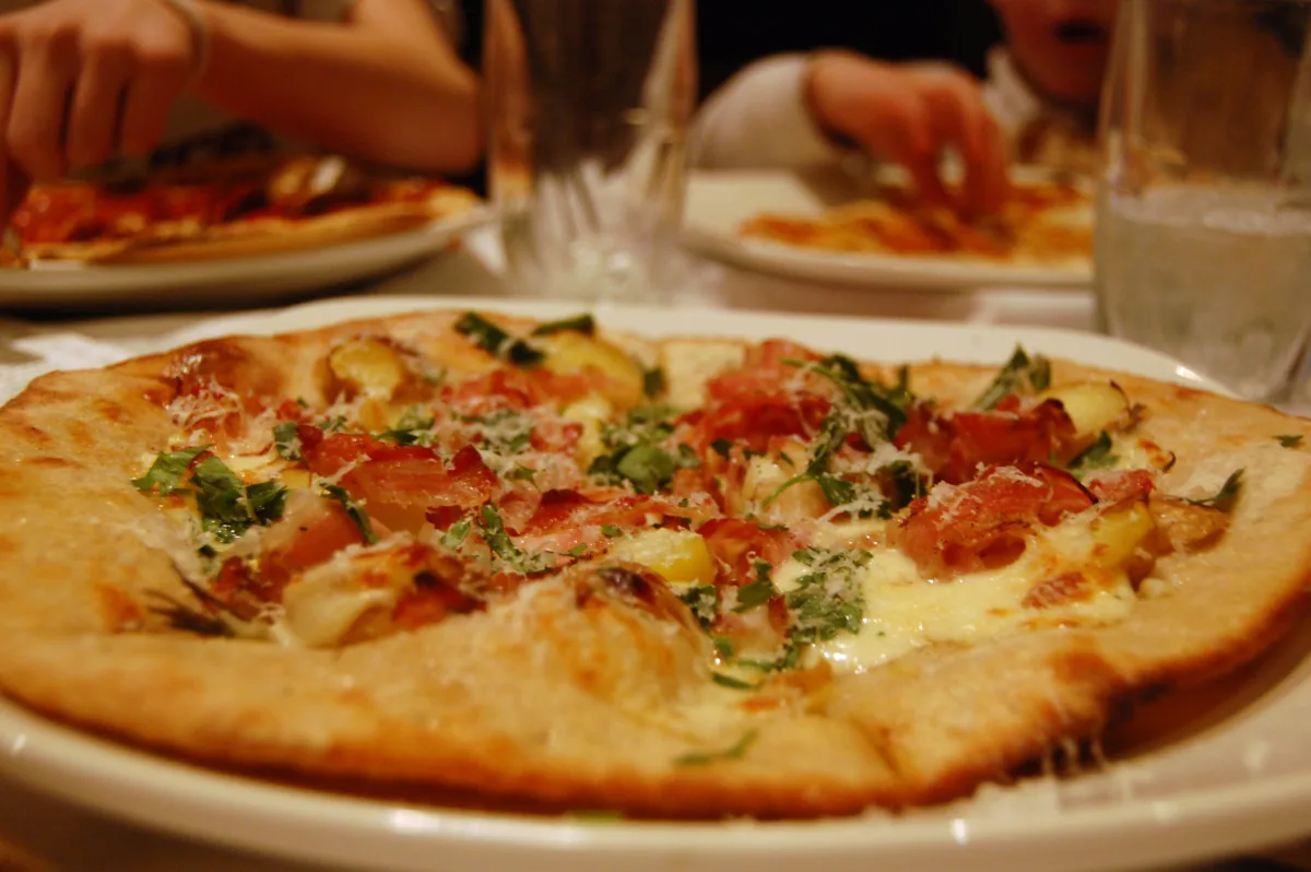 Round crispy hash brown potato crust topped with melted cheese and pizza toppings